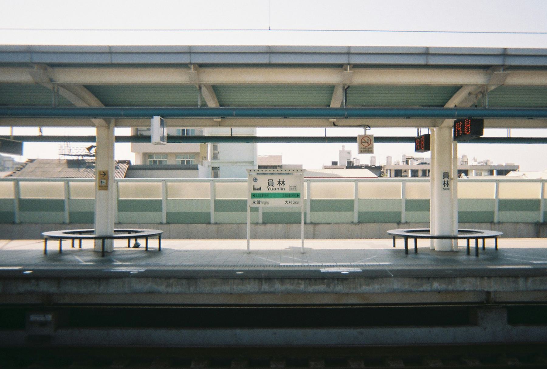 Empty train platform with sign that reads ‘Yuanlin’. Film photograph.
