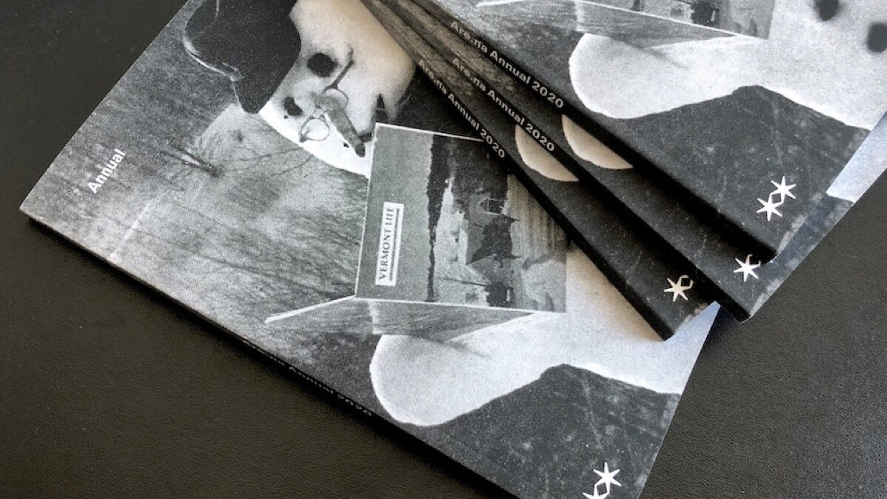 A stack of black-and-white magazines titled "Annual 2020". The cover features a stylized image of a snowman holding a book, with a blurred outdoor scene in the background.