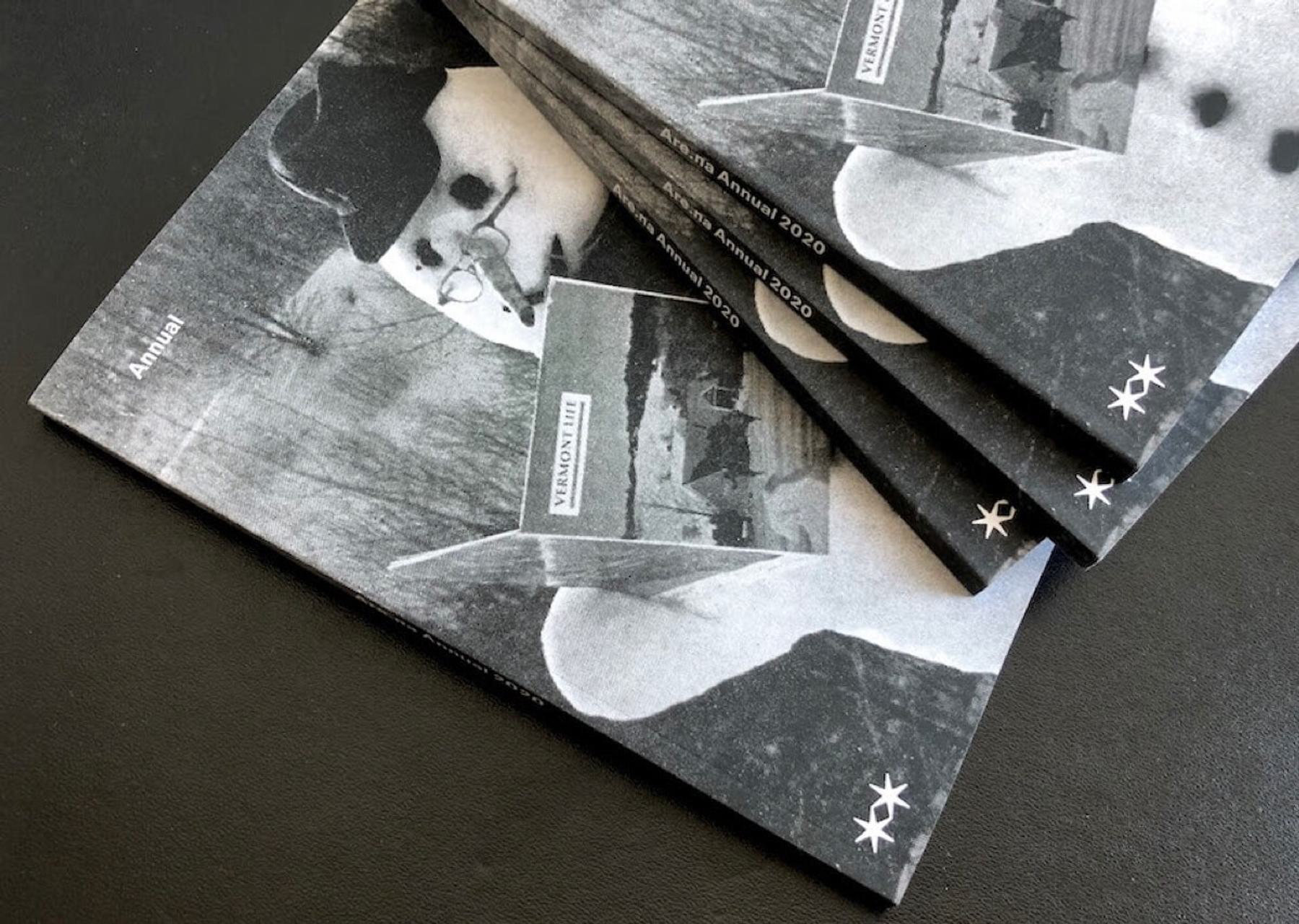 A stack of black-and-white magazines titled "Annual 2020". The cover features a stylized image of a snowman holding a book, with a blurred outdoor scene in the background.