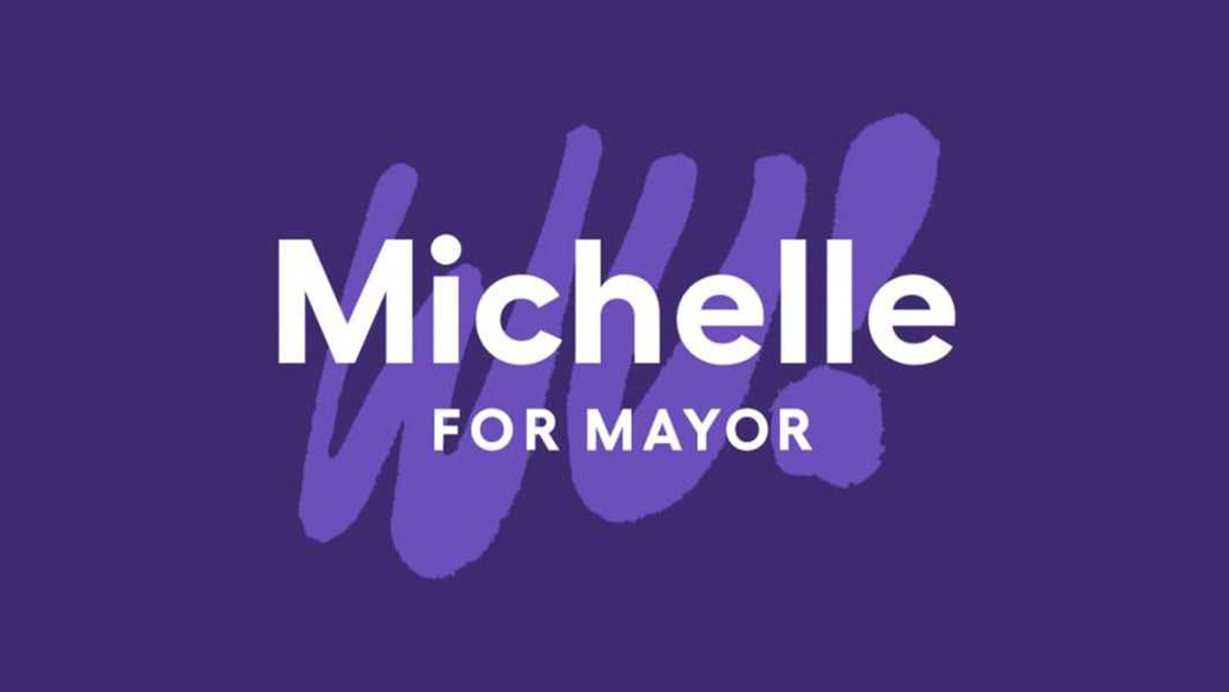 A campaign sign with text "Michelle for Mayor" in bold, with the "Wu!" brushstroke logo in the background.
